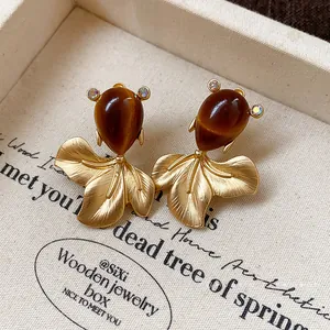 Vintage goldfish stud earrings featuring teardrop brown stones with a matte gold finish