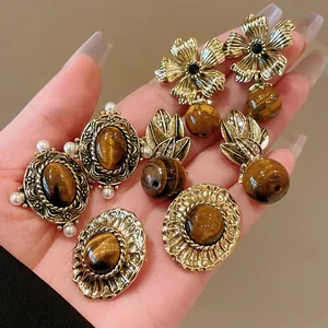 Close-up detail view of vintage palace style tiger eye earrings with elegant pearl accents