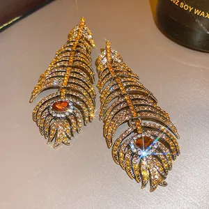 Dettaglio di orecchini vintage a forma di piuma con zircone ambra