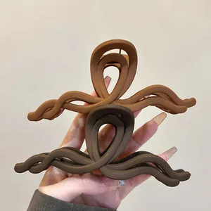 Vista dettagliata di fermagli per capelli opachi marroni a onde con design minimalista