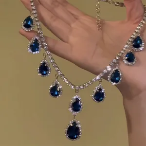 Detailed view of luxury necklace with blue teardrop pendants and crystals