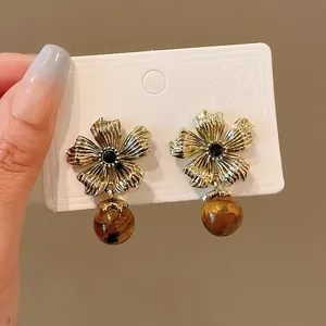 Vintage flower stud earrings with brown tiger eye stone pendants and silver needles.