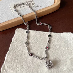 Vintage silver necklace featuring colorful rhinestones and an engraved cube pendant charm