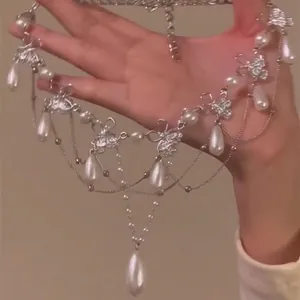 Detailed macro view of an elegant silver necklace with pearls and butterfly pendants