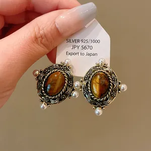 Vintage palace style stud earrings featuring oval tiger eye stones and small pearls