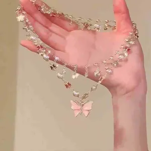 Elegant double-layered necklace featuring a pink butterfly pendant with pearls and crystals
