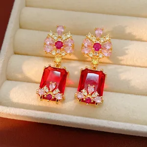 Dettaglio di orecchini floreali vintage di lusso con grande cristallo rosso rettangolare