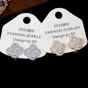 Macro detail of 18k gold plated flower ear clips with sparkling cubic zirconia
