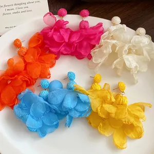 Vista dettagliata di orecchini a fiore in chiffon e rafia con eleganti perle