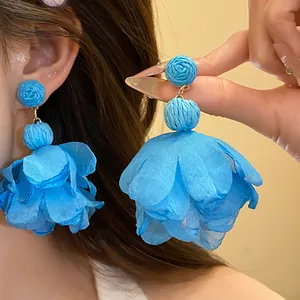 Orecchini pendenti con fiori in rafia e chiffon blu per un look da vacanza estiva.