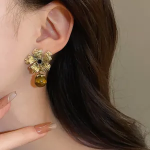 Close-up of vintage flower earrings with tiger eye stone drop and silver needle