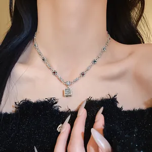 Detailed macro shot of a vintage silver necklace with a cubic cross pendant on an Asian model.