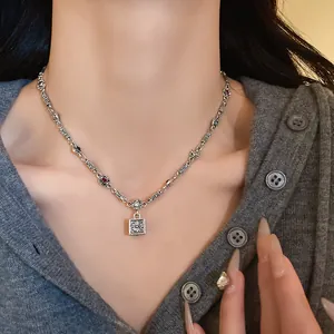 Close-up of a vintage square pendant necklace with colorful stones on an Asian model.