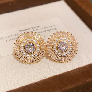 Dettaglio orecchini a lobo vintage in oro a forma di fiore con diamante e perle