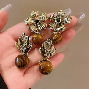 Detailed view of vintage tiger eye stone earrings with floral and leaf motifs