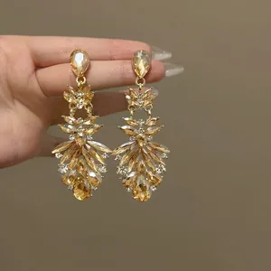 Detailed view of luxury floral drop earrings with champagne crystals and gold base