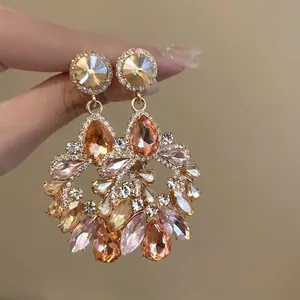 Close-up of elegant champagne crystal flower earrings with sparkling amber teardrops