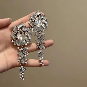 Detail view of oversized sparkling zircon flower earrings with cascading tassels