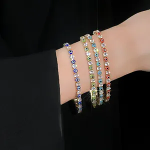 Close-up view of four colorful Evil Eye tennis bracelets with sparkling zircons on a wrist.