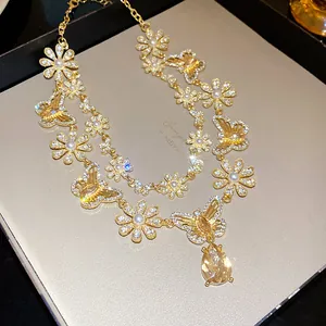 Elegant vintage gold necklace featuring butterfly motifs and crystals with pear drop