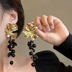 Exquisite close-up of vintage gold floral earrings featuring elegant black beaded drops