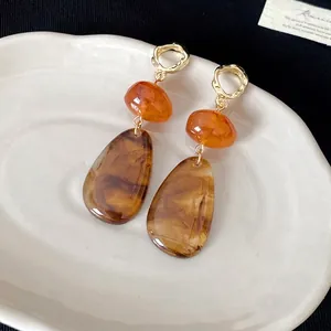 Vintage water-drop contrast color earrings presented on an elegant white ceramic tray