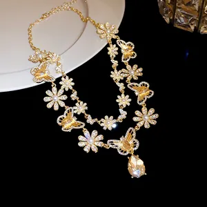 Detail of a gold-toned necklace with crystal butterflies and daisy floral patterns.