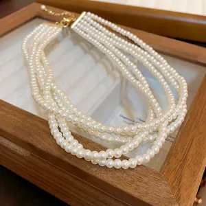 Detail view of multi-layered white pearl necklace in a wooden display box