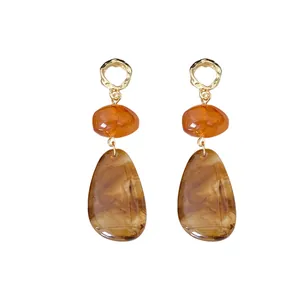 Vintage-style drop earrings featuring amber resin teardrops and gold-tone metal accents