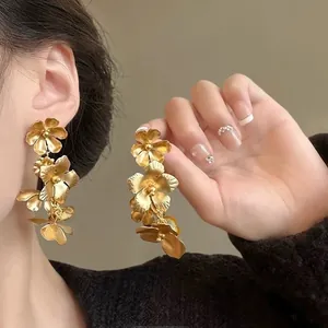 Detailed close-up view of gold cascading floral earrings worn by an elegant model