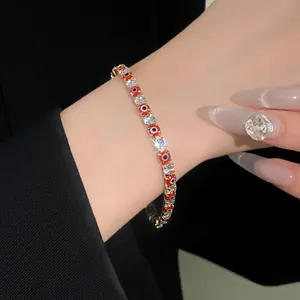Close-up of elegant evil eye bracelet with red beads and sparkling zircon stones