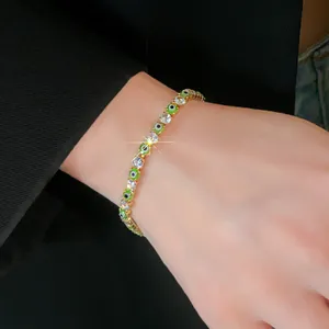 Detailed shot of evil eye tennis bracelet with green beads and cubic zirconia
