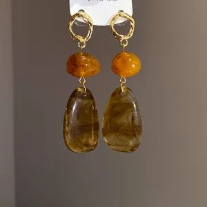 Detailed view of vintage amber-colored water drop earrings with marble resin texture