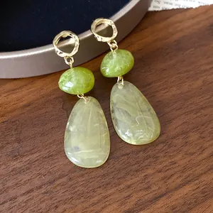 Close-up detail of vintage green marbled teardrop earrings with hammered gold hoops