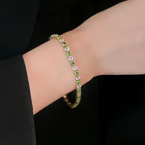 Detail view of gold-plated evil eye tennis bracelet with clear cubic zirconia on wrist