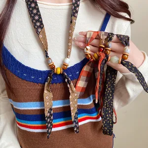 Macro detail of bohemian retro necklace featuring colorful chiffon fabric and wooden beads
