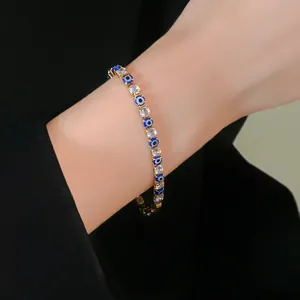 Detailed close-up of a gold Evil Eye tennis bracelet with clear cubic zirconia stones