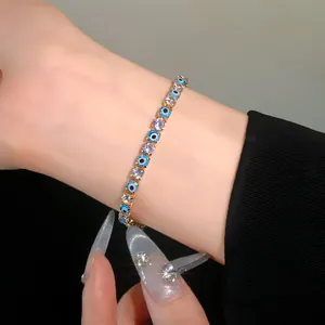 Detailed view of gold-tone tennis bracelet with blue evil eye beads and clear cubic zirconia