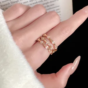 Détail d'une bague élégante à trois couches en forme de bambou dorée ornée de zircons