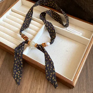 Detailed close-up view of bohemian fabric necklace featuring ceramic and wood beads.