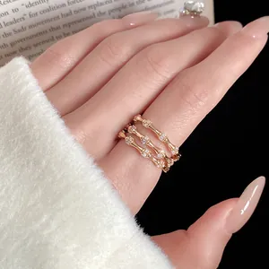 Gros plan d'une bague en bambou doré à trois couches sertie de zircons étincelants