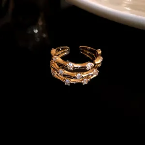Détail d'une bague triple épaisseur motif bambou en plaqué or sertie de zircons.
