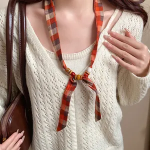 Close-up of Bohemian plaid fabric necklace with wooden and ceramic beads
