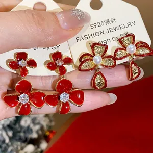 Close-up of red flower stud earrings with zircons and pearls on S925 silver needles