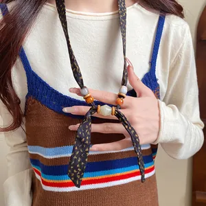 Close-up detail of Bohemian chiffon fabric necklace with wooden and ceramic beads
