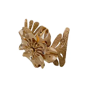Elegant gold-tone metal open cuff bracelet featuring a large blooming flower design