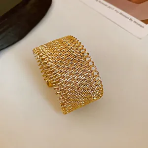 Elegant gold woven mesh wide cuff bracelet with a minimalist chic open design style.