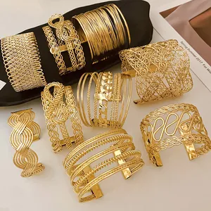 Various minimalist gold open cuff bracelets with intricate braided and wire designs