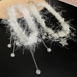 Gros plan d'un collier en peluche blanche avec glands en cristal et pendentif étoile