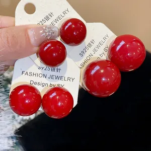 Detailansicht glänzend roter Perlenohrstecker mit S925-Silbernadeln auf Karten.